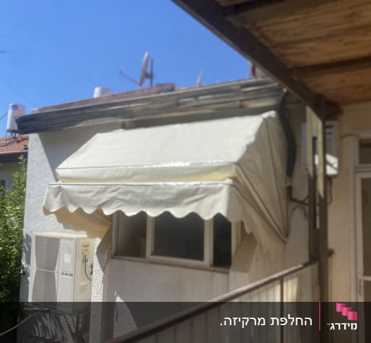סוכך בד לבן מעל חלון בית